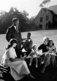 Plano general de Eva Rubinstein, Arthur Rubinstein, Paul Rubinstein, John Rubinstein, Aniela Rubinstein y Alina Rubinstein en brazos de Aniela posando sentados en el jardín