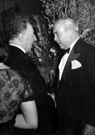 Plano medio de Arthur Rubinstein (perfil derecho) y un hombre (perfil izquierdo) charlando
