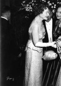 Plano general de Eva Rubinstein charlando con una mujer. Detrás Arthur Rubinstein y Aniela Rubinstein observan