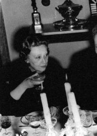 Plano medio de Arthur Rubinstein cenando con Olga de Cadaval (a su izquierda) y una mujer