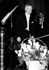 Plano general de Arthur Rubinstein en el escenario, ante un ramo de flores. Witold Rowicki aplaudiendo al fondo