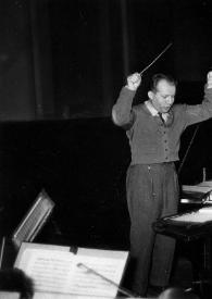 Plano medio de Arthur Rubinstein (perfil izquierdo) sentado al piano y Jerzy Katlewicz, con la batuta en la mano derecha, dirigiendo la orquesta