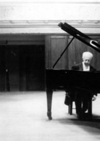 Plano general de Arthur Rubinstein sentado al piano. A Arthur se le ve entre la base del piano y la tapa