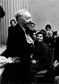 Plano medio de Arthur Rubinstein (perfil izquierdo) saludando al público entre los que se encuentran Sol Hurok y Aniela Rubinstein