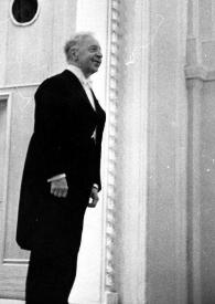 Plano general de Arthur Rubinstein (perfil derecho) de pie, en el escenario, saludando al público