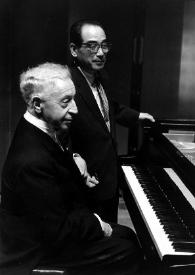 Plano medio de Arthur Rubinstein (perfil derecho) sentado al piano junto a Yoshitaka Saito (afinador de pianos)