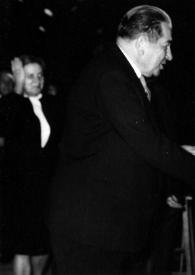 Plano medio de un hombre (perfil derecho) y Arthur Rubinstein (perfil izquierdo) estrechando las manos.