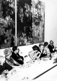 Plano general de las mesas, en el centro de la mesa presidencial: Alina Rubinstein, Isaac Stern, David Ben-Gurion, Arthur Rubinstein de pie hablando a través de un micrófono entre otros invitados.