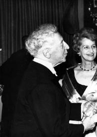 Plano medio de Arthur Rubinstein (perfil derecho), Aniela Rubinstein y Helen H. Hull (perfil izquierdo) saludándose, con un hombre al fondo