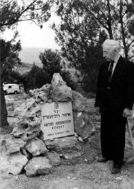 Plano general de Arthur Rubinstein (medio perfil izquierdo) observando la placa conmemorativa entre las rocas