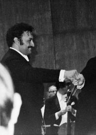 Plano medio de Zubin Mehta (perfil derecho) saludando a Arthur Rubinstein (perfil derecho) junto a la orquesta, en el escenario