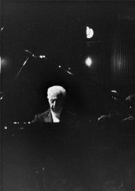 Plano general del escenario del concierto: la orquesta, Henryk Czyz (de espaldas) dirigiéndola y Arthur Rubinstein (de frente) sentado al piano. A Arthur se le ve entre la tapa y la base del piano.
