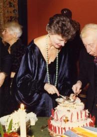 Plano general de Nora Auric al fondo, delante: Marie, Baronesa de Rothschild, Arthur Rubinstein y Aniela Rubinstein partiendo la tarta. Detrás Jacques Février les observa