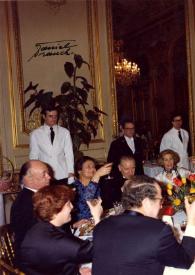 Plano general de Simone Veile, el Señor Agham (Pintor), Aniela Rubinstein y el resto de los invitados haciendo un brindis durante una recepción.