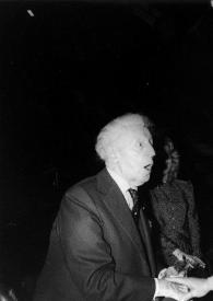 Plano medio de Arthur Rubinstein (perfil derecho) saludando a la Señora de Raymond Barre, detrás de ellos Annabelle Whitestone