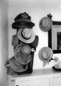 Plano general de Aniela Rubinstein posando mientras se prueba un sombrero.