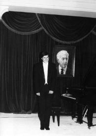 Plano general de Andrzej Jablonski posando en el escenraio junto al piano, al fondo un cuadro con el retrato de Arthur Rubinstein