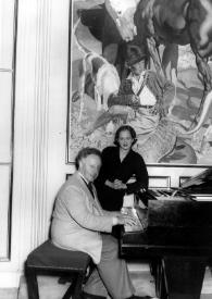 Plano general de Arthur Rubinstein sentado al piano, detrás Aniela posa apoyada en el piano
