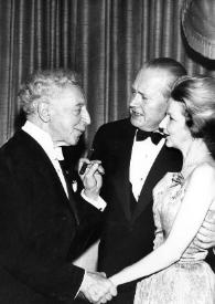 Plano medio de Arthur Rubinstein charlando con un hombre y una mujer charlando