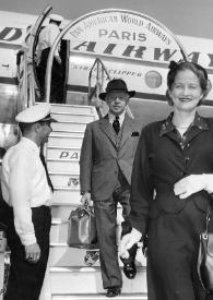 Plano general de Aniela y Arthur Rubinstein posando mientras bajan las escalerillas de un avión