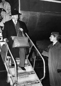 Plano general de Aniela y Arthur Rubinstein bajando las escalerillas de un avión, abajo les espera una azafata