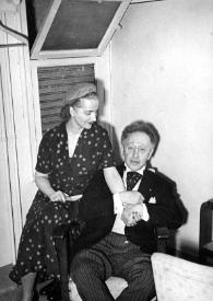 Plano general de Aniela Rubinstein sentada junto a Arthur Rubinstein posando cogidos de la mano