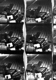 Plano general de Lorin Maazel dirigiendo la orquesta, Arthur Rubinstein (perfil izquierdo) sentado al piano y la orquesta en diferentes posiciones