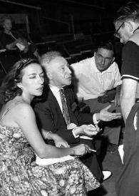 Plano medio de una mujer, Arthur Rubinstein, un hombre y Henry Haftel Zvi charlando, al fondo Aniela Rubinstein les observa