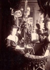 Plano general de Arthur Rubinstein, de niño, y Alice Rosentower posando, de espaldas a un espejo en el que se puede apreciar la figura de la Señora Hartzell realizando la fotografía