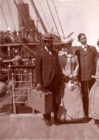 Plano general de un hombre, Emily Winifred Cottorell, un hombre y Señora de Hartzell posando en la cubierta del Transatlántico S/S Friedrich der Grosse antes de zarpar del muelle