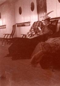 Plano general de Emily Winifred Cottrell leyendo, la Señora Rosentower posando y la Señorita Mann leyendo, las tres sentadas en unas hamacas con unas mantas sobre las rodillas, en la cubierta del barco