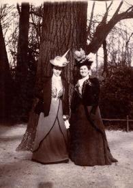 Plano general de Emily Winifred Cottrell y Señora de Rosentower posando junto al tronco de un gran árbol
