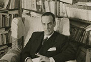 Camilo José Cela sentado ante la biblioteca de su casa, 1951 (Fuente: Fundación Pública Gallega Camilo José Cela. Localización: Biblioteca Virtual del Patrimonio Bibliográfico).