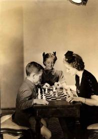 Plano general de Paul Rubinstein y Aniela Rubinstein jugando al ajedrez mientras Eva Rubinstein les observa