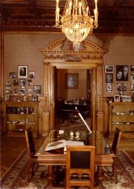Portada:Plano general de una de las salas del Museo con una mesa en el centro que sujeta una escultura de las manos de Arthur Rubinstein en bronce encerradas en una pirámide de cristal. Además de vitrinas con objetos personales y fotografías.