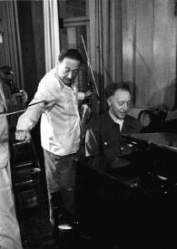 Portada:Plano general de Arthur Rubinstein sentado al piano y Jascha Heifetz de pie junto a el