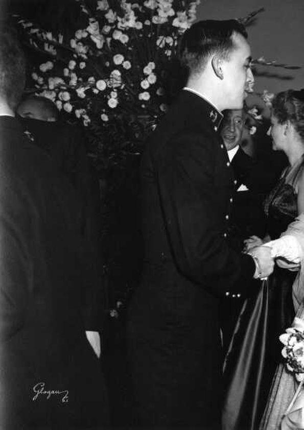 Plano general de Eva Rubinstein estrechando la mano a un hombre. Detrás ...