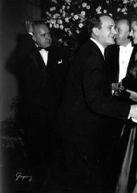 Portada:Plano general de Eva Rubinstein saludando a un hombre. Detrás, Aniela y Arthur Rubinstein charlando con otro hombre