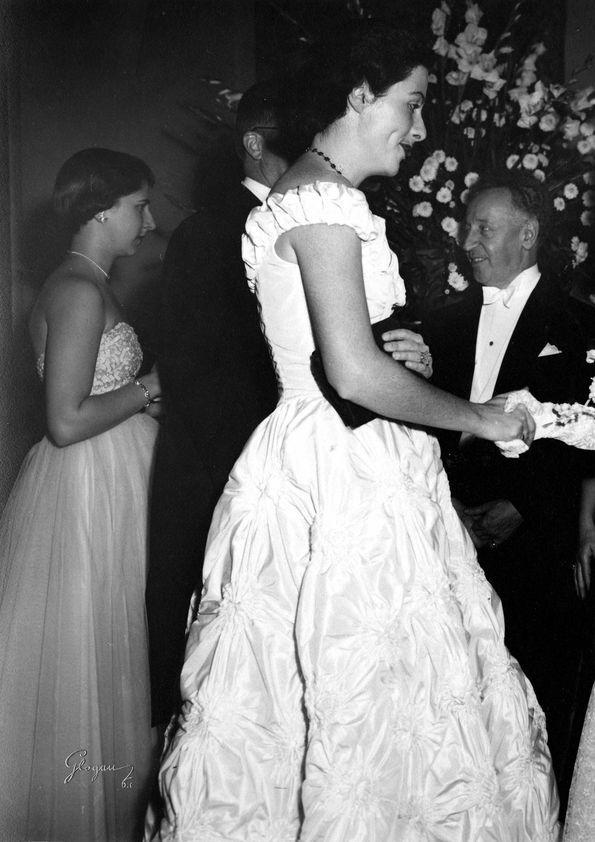 Plano general de Eva Rubinstein estrechando la mano a una mujer. Detrás ...