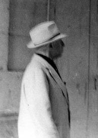 Portada:Plano medio de Arthur Rubinstein (perfil derecho), con sombrero, mirando un cartel que anuncia un recital de Chopin interpretado por él