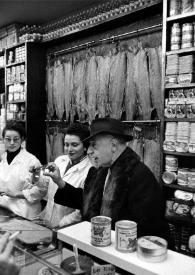 Portada:Plano medio de Arthur Rubinstein probando productos en el interior de la tienda junto a dos vendedoras