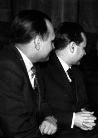 Portada:Plano medio de Arthur Rubinstein sentado, rodeado de hombres, y Aniela Rubinstein en un extremo del banco