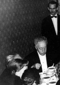 Portada:Plano medio de Arthur Rubinstein, Ewa Bandrowska y Antoni Slonimski, sentados a la mesa comiendo