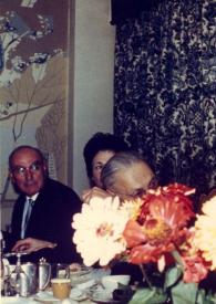 Portada:Plano medio de tres personas y Arthur Rubinstein, charlando con un hombre y una mujer, sentados en una mesa