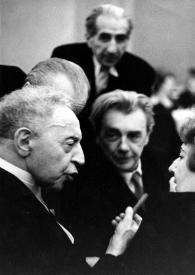 Portada:Plano medio de Arthur Rubinstein (perfil derecho) charlando con Ewa Bandrowska