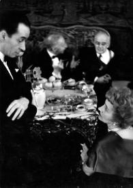 Portada:Plano medio de Aniela Rubinstein (perfil derecho) charlando con Witold Rowicki y Arthur Rubinstein al fondo charlando con un hombre