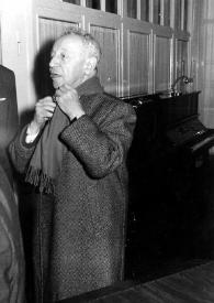 Portada:Plano general de Arthur Rubinstein (medio perfil izquierdo) con gabardina poniéndose la bufanda