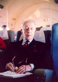 Portada:Plano medio de Arthur Rubinstein sentado en un avión, con las gafas apoyadas en un libro que lleva sobre sus rodillas