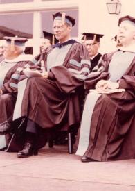 Portada:Plano general de Arthur Rubinstein vestido con toga y birrete, sentado junto a otros doctorados