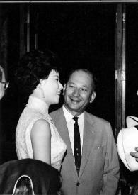 Portada:Plano medio de una mujer y un hombre charlando con Arthur Rubinstein (perfil izquierdo) con un sombrero entre las manos, junto a otro hombre
